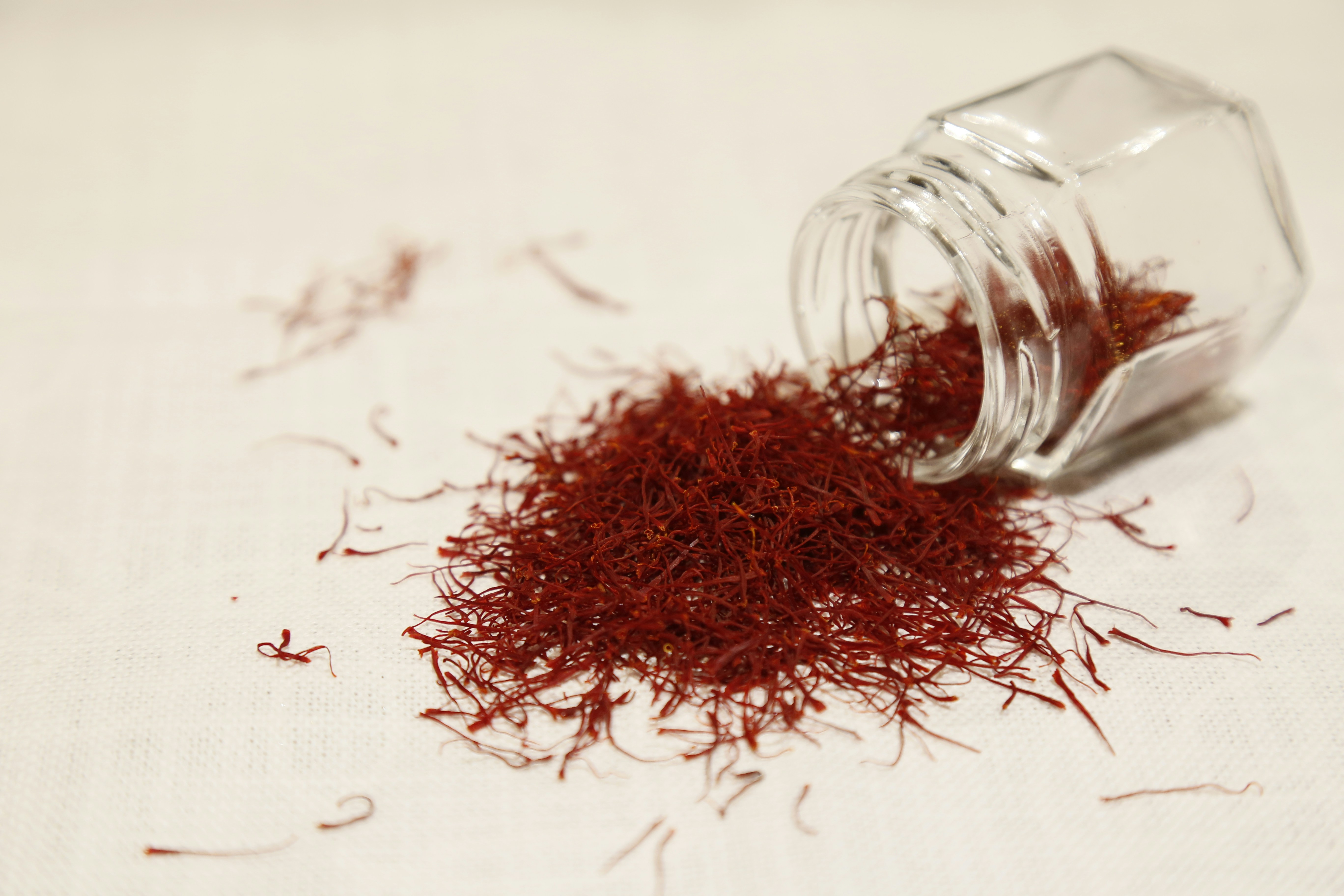 Saffron threads spilling from a glass jar